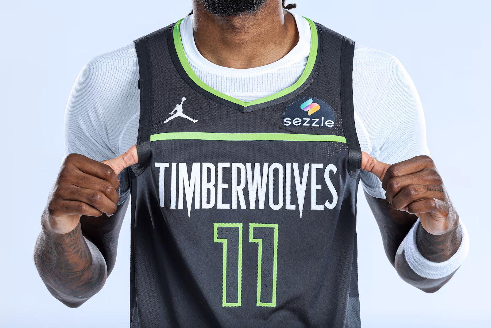 A timberwolves jersey has sezzle's logo in the top right corner